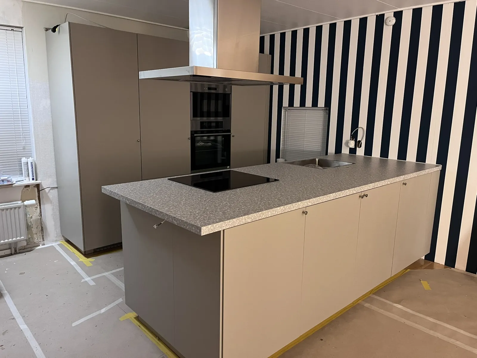 Totalrenovering Halmstad – Köksö med induktionshäll och fläkt under montering