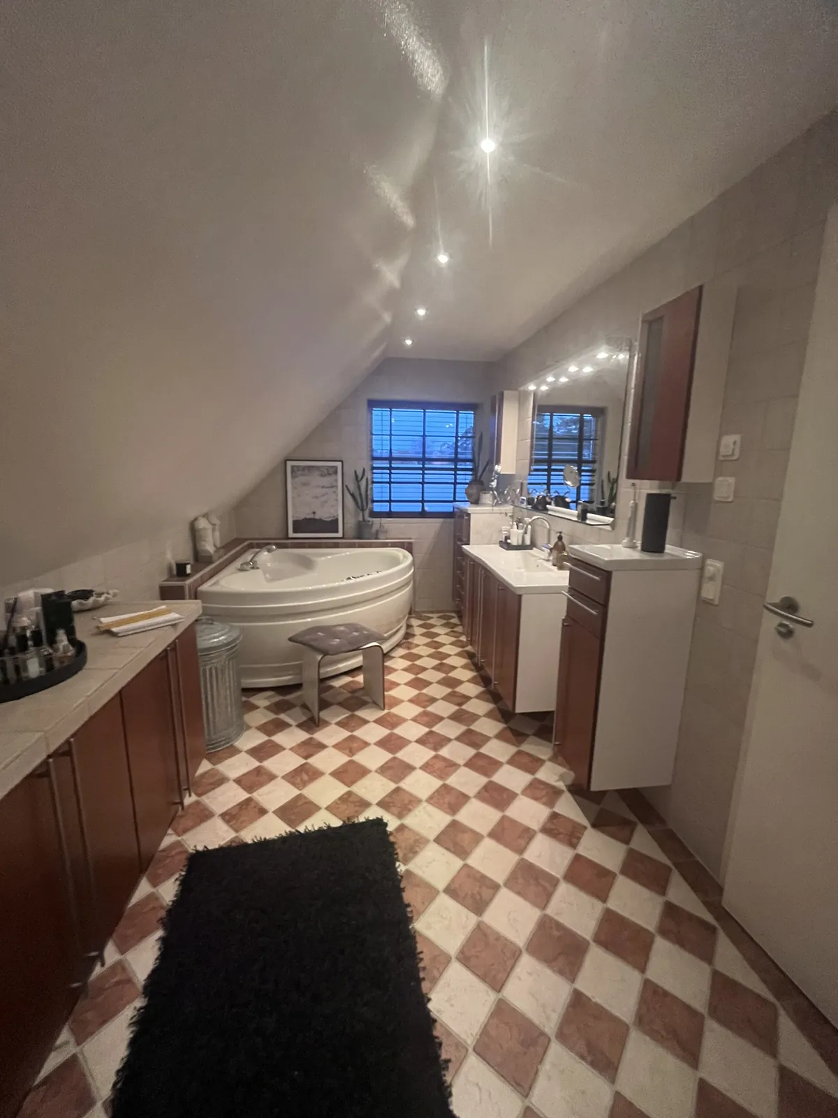 Totalrenovering Halmstad – Långsmalt badrum med rutigt klinkergolv, badkar och kommod