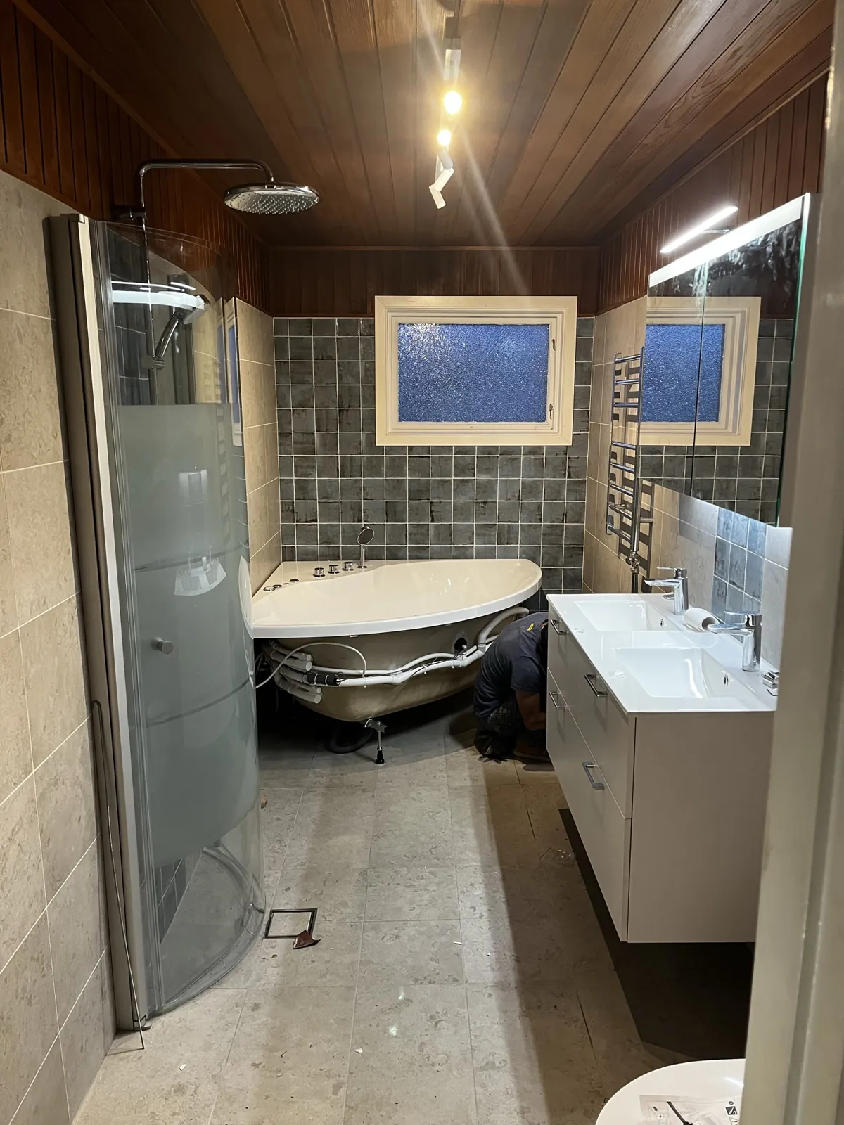 Badrum med blågröna kakelplattor, badkar och duschhörna